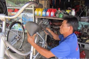 陳文富忙著翻新舊自行車。