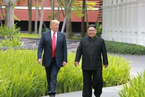 特朗普與金正恩走過嘉佩樂酒店花園時交談的情景。（圖源：路透社）
