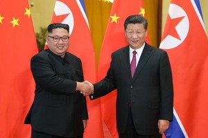 習近平（右）與金正恩握手致意。 （圖源：新華網）