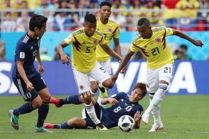 哥倫比亞（黃衣）與日本拼搶激烈。