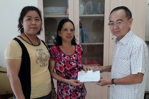 本報編委兼編輯部主任范興（右）在第十一郡第十四坊祖國陣線委員會代表見證下移交給她。