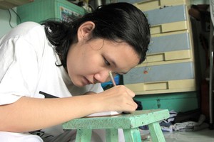 每當寫字或看書，阿泉都要把頭低下。