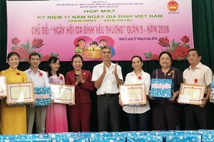 第五郡人委會副主席張庚波(右四)向越華模範家庭頒發獎章。