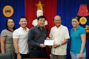 第五郡福建溫陵會館(觀音廟)理事會將贊助款項轉交給《西貢解放報》副總編輯、本報主編阮玉英(紅藍)。