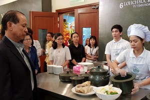 李玉明總經理(左一)指引廚師用瓷鍋煮食品 給來賓品嚐。