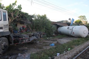 猛烈的撞擊使到槽車被拋出鐵軌外，車上裝液化氣的槽體被拋離且撞中附近一家民房的鐵皮瓦屋頂。（圖源：N.Phê）
