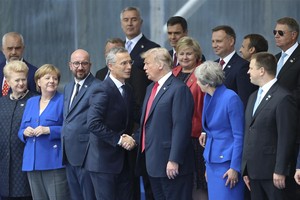 北約秘書長斯托爾滕貝格(中左)與美國總統特朗普(中右)在北約峰會開幕式上握手。（圖源：新華網）