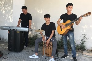 在峴港市人行道上表演音樂的大學生小組。