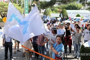 市民揮舞韓半島旗歡迎朝鮮乒乓球代表團來訪。（圖源：韓聯社）