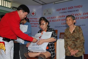 市紅十字會副主席張子諒向落葉劑受 害者和貧困殘疾人士贈送禮物。