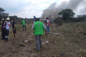 搜救專隊趕到飛機墜落現場開展應急救護措施。（圖源：AP）