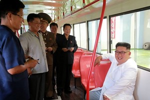 金正恩（白衣）視察無軌電車工廠。（圖源：KCNA）