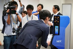 工作人員示範使用ID卡及人臉識別技術。（圖源：AP）