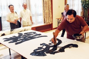 林漢城在百米長卷即席揮毫“騰飛”二字。