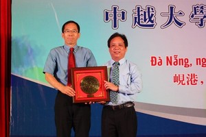 峴港市大學校長阮玉武（右）向中國共青團中央學校部副部長石新明贈送紀念品。（圖源：江青）