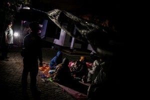 許多民眾不敢進入屋內，在路邊的簡易避難所過夜。（圖源：路透社）