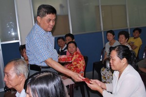 梁栢滔先生向病人發放贊助金。