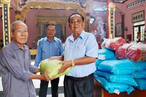 鄭氏宗祠榮譽理事長鄭紹明（右）向宗親派發盂蘭節禮物。