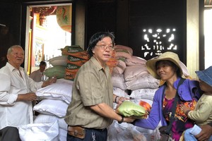 霞漳會館理事長何天輝向貧困戶發送大米。