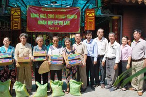 浸石天后宮理事長張敬和以及各理事向貧困同胞派發禮物。