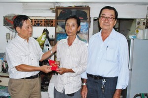 吳老師的兒子林偉忠（中）代表接受慰問金。