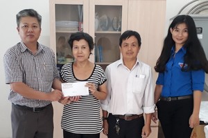 本報編委黎曰孟雄（左一）把讀者捐助的款項移交給戶主孔濟河的太太。