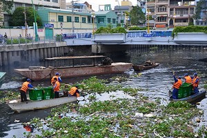 清潔工人正在河涌上打撈垃圾。