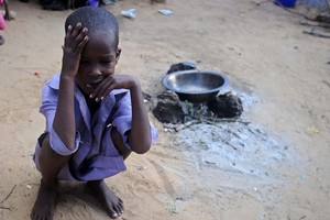 在索馬里首都摩加迪沙郊外的難民營，一個孩子蹲坐在地。（圖源：Getty Images）