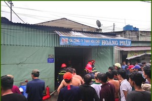 眾人圍著看消防隊員們勇進失火的化工原料倉裡進行滅火。（圖源：Tin Tin）