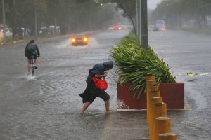 菲律賓民眾頂著狂風暴雨出行。（圖源：AP）