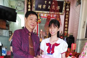 鄧氏宗祠理事長鄧榮(左)向鄧美心 特別優秀生頒發三份獎學金。