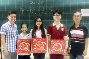 崇華華文中心校政主任徐永華老師（右一）和曾廣健老師向各學生贈送月餅。