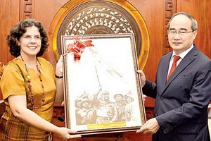 古巴駐越南大使利亞尼斯‧托里斯‧里韋拉（左）向市委書記阮善仁贈送紀念品。（圖源：越勇）