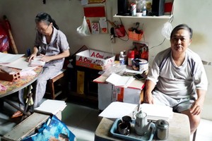 盧妹兩夫婦替人加工請柬掙錢過活。