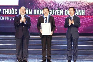 中央宣教部部長武文賞(右)與河內市委書記黃忠海(左)給河內婦產醫院院長阮維英副教授、博士頒發“2018年首都優秀公民”稱號。（圖源：越通社）