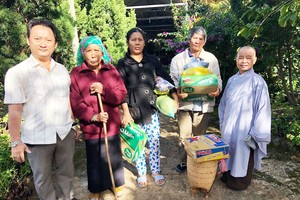 該廟慈善組組長鄒國榮(左一)與寶意禪寺 住持(右一)向少數民族貧困戶派發禮物。
