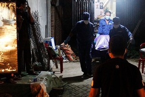 仵工將死者遺體搬出案發地點送上救護車。