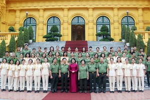 國家代主席鄧氏玉盛（中）同榮獲“2017年公安婦女模範”的人民公安幹部、戰士代表團在主席府前合影留念。（圖源：文令）