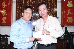 本報主編阮玉英(左)接受周華邦住持贊助善款。