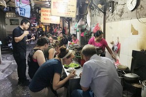 導遊向外國遊客介紹河內市同春街市小食。
