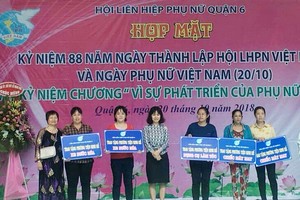 華人婦女應氏蓮(左一)向貧困婦女贈送謀生工具。