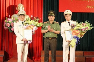 公安部副部長阮文成上將分別向范長江大校（左）和杜文宏大校（右）轉授公安部長簽發的調任《決定》。（圖源：寧家）
