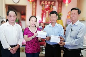 宗祠理事長黎志有(右一)把兩份善款交給 坊祖國陣線委員會主席黎氏金清水女士代收。