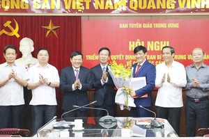 中央宣教部長武文賞（中）向阮清平同志贈送鮮花表示祝賀。（圖源：tuyengiao.vn）