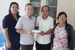本報編委兼編輯部主任范興（左二）把讀者捐助的款項移交給戶主吳育勇、張南瑛夫婦。