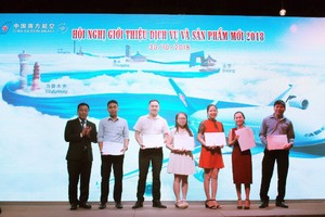 南航駐本市辦事處總經理崔恆(左一) 向幸運者贈送旅遊券。