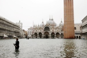 一名男子站立在聖馬克廣場積水中。（圖源：AFP）