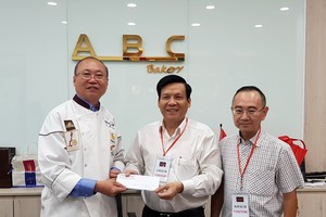 高肇力總經理（左）把贈報款項交給本報主編。