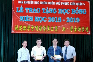 市民族處副主任梁鴻德（左一）與溫陵會館理事長 張子諒（右一）頒發獎學金給碩士生。