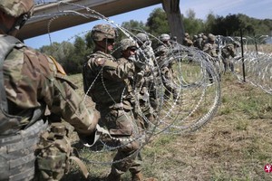 在美國與墨西哥兩國之間的邊界上，美國士兵架起了層層的有刺鋼絲圈，要防止中美洲移民入境。 （圖源：法新社）